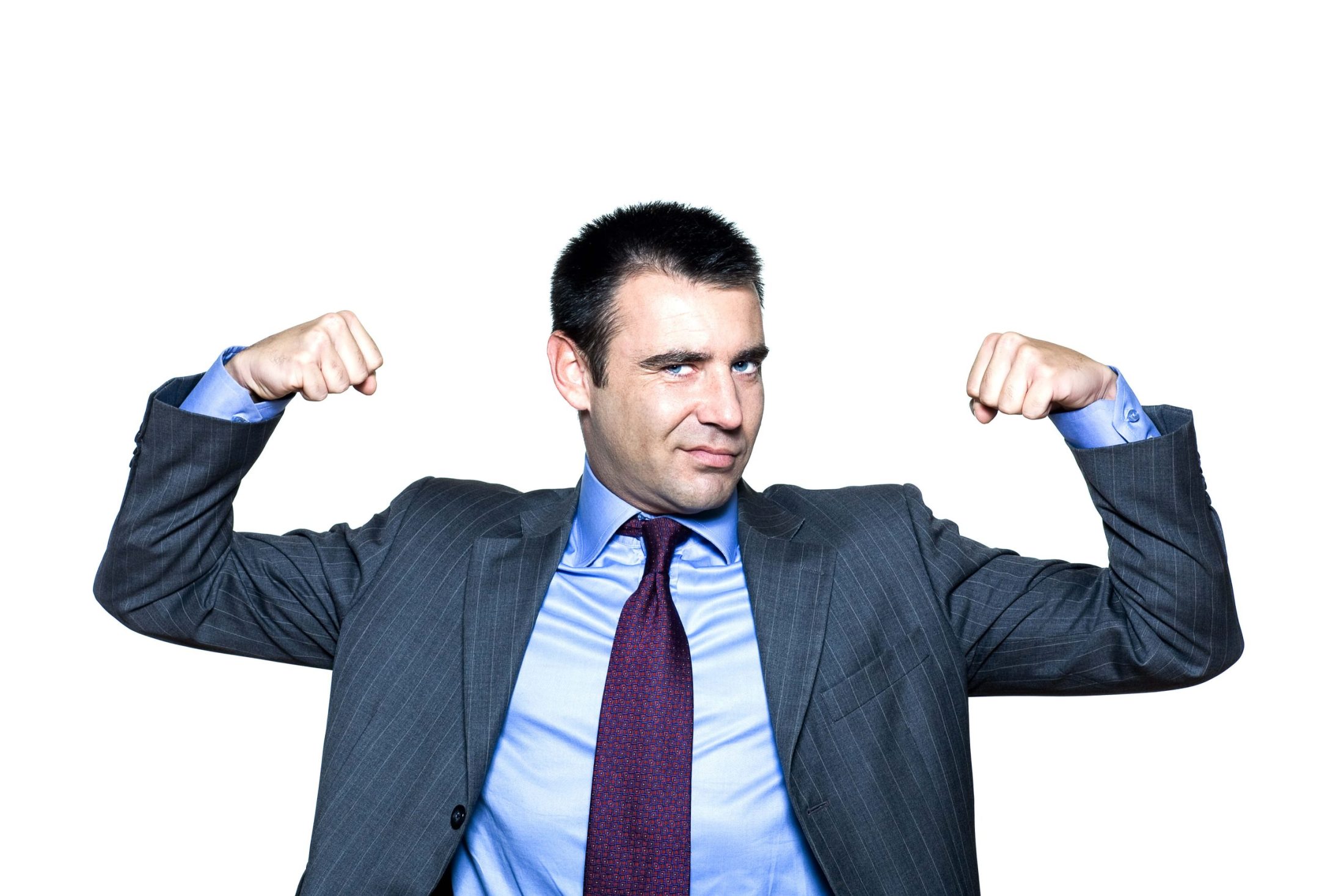  A man in a suit flexing his muscles with a confident expression on his face.